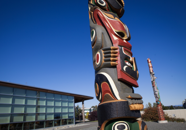 Totem pole in front of a building. 