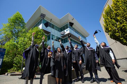 a group of students in convocation regalia throwing up their graduation caps