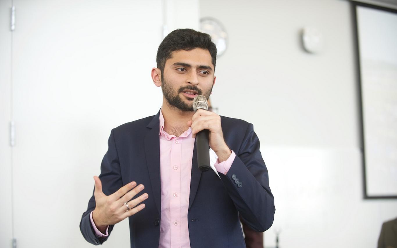 A speaker holding a microphone on a stage
