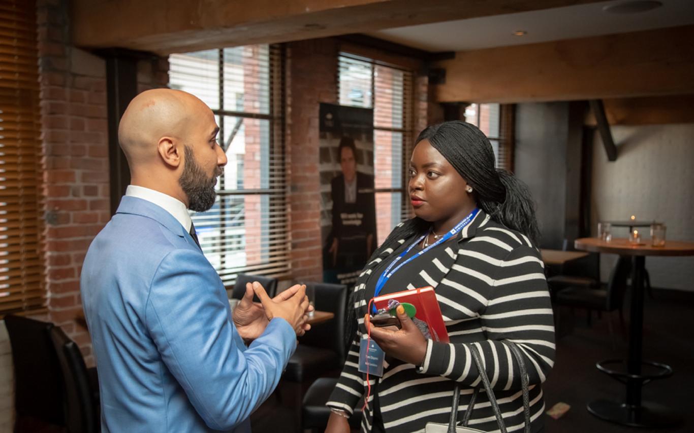 A female student speaking with a male employer