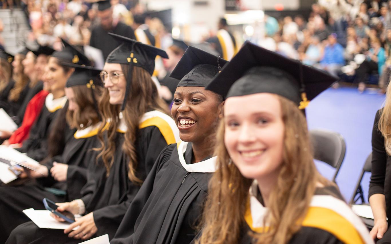 Smiling VIU grads wearing graduation regalia