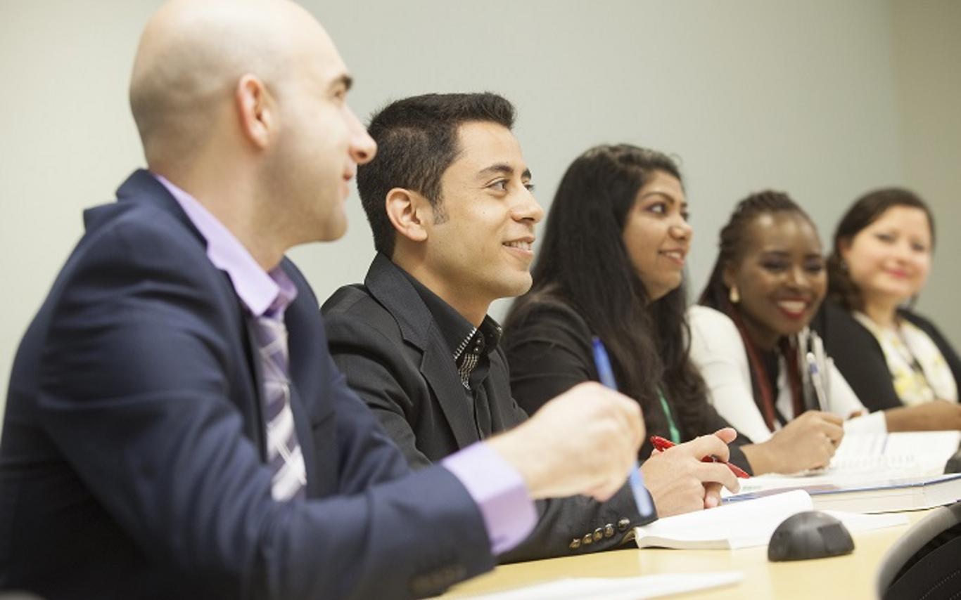 A team of students sitting together at a desk ready to work